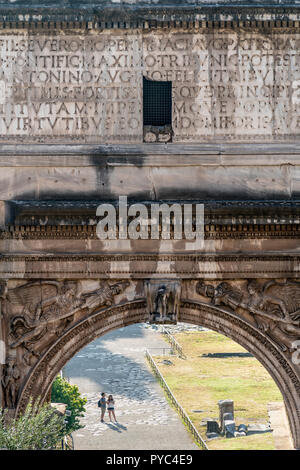 Two tourist, seen through the Arch of Septimius Severus,  explore the Roman Forum , Rome, Italy. Stock Photo