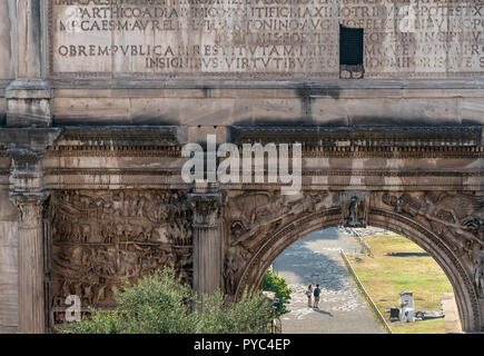 Two tourist, seen through the Arch of Septimius Severus,  explore the Roman Forum , Rome, Italy. Stock Photo