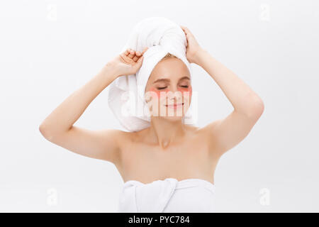 Young beautiful yawning woman with collagen pads under her eyes on a light background. Spa, eye skin care. Stock Photo