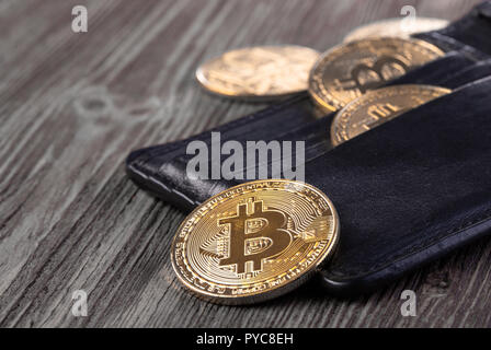 Popular cryptocurrency in leather wallet on wooden table Stock Photo
