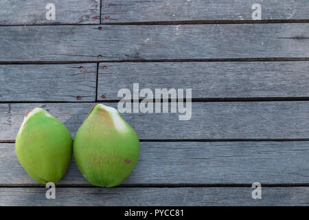 Green coconuts on a wooden floor Stock Photo