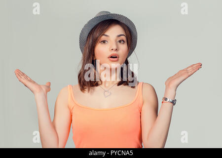 Portrait dumb looking woman arms out shrugs shoulders I don't know isolated on loght gray wall background. Negative human emotion, facial expression b Stock Photo