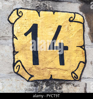 House number fourteen 14 painted black on gold in a square scroll design in stylised cursive font in Brussels and Sweden Stock Photo