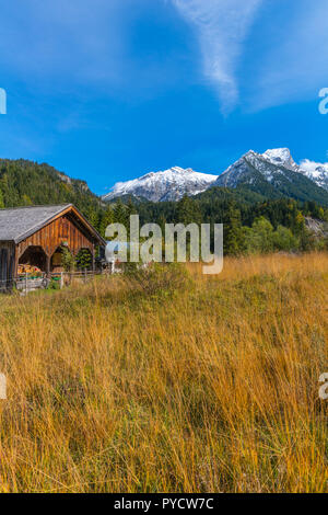 Alpine farm in the Rissbach Valley,  snow-covered mountains in autumn time, Vomp, Tyrol, Austria Stock Photo