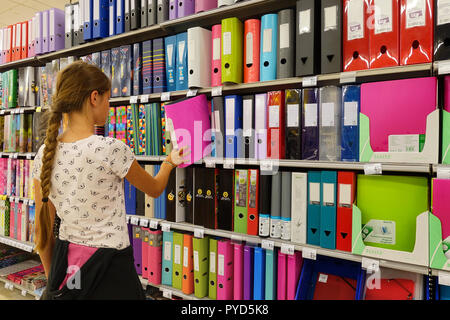 Girl selecting a school map in a Carrefour hypermarket Stock Photo