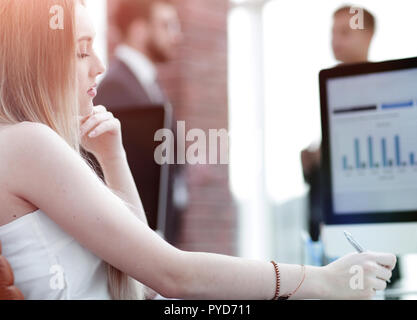 Business woman working in office with business graph on computer Stock Photo