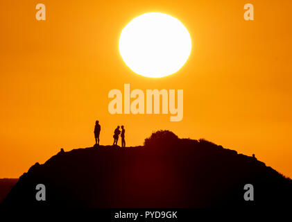 26/10/18: Cyprus:  Tourists view the setting sun from the top of Petra tou Romiou ("Rock of the "Roman") also known as Aphrodite's Rock, near Paphos Stock Photo