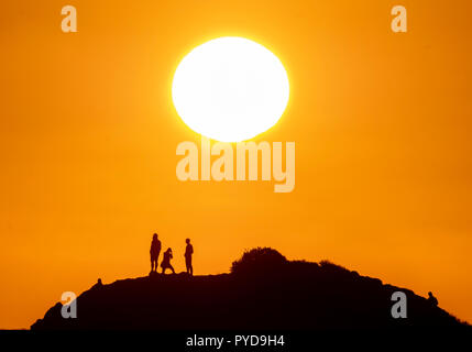 26/10/18: Cyprus:  Tourists view the setting sun from the top of Petra tou Romiou ("Rock of the "Roman") also known as Aphrodite's Rock, near Paphos Stock Photo