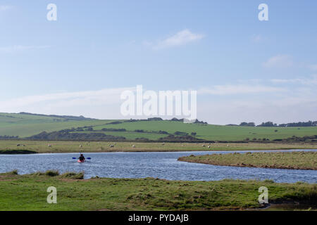 Two people kayaking on the Cuckemere on a sunny day. Blue sky with some light white clouds. Stock Photo