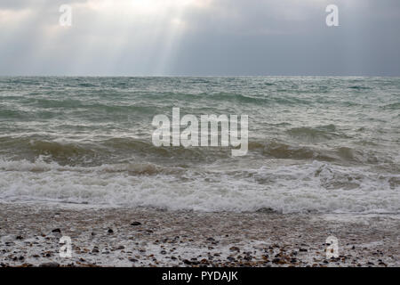 Light through the clouds falling on the sea. Stock Photo