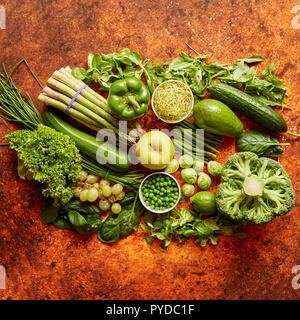 Fresh, natural, green vegetables, fruits and herbs assortment placed on a rusty metal background. Top view. Stock Photo