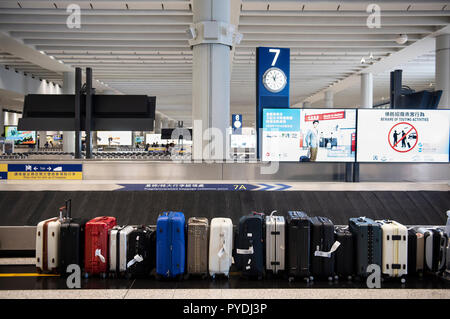 Airport staff has aligned numerous suitcases at Hong Kong international airport. Stock Photo