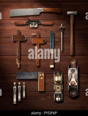 Precision carpentry tools hanging on a wooden panelled wall Stock Photo