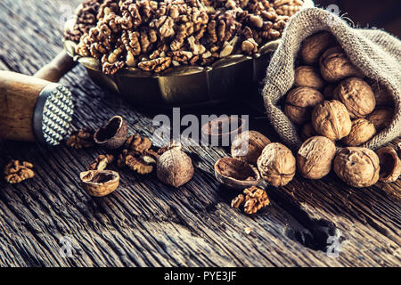 Walnut kernels whole walnuts in burlap sack and vintage bowl. Stock Photo