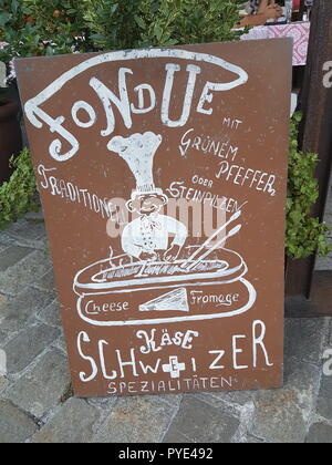 Old restaurant sign advertising fondue in Interlaken, Switzerland Stock Photo