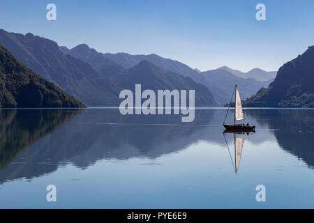 Small boat sailing on Lake Idro in northern Italy Stock Photo