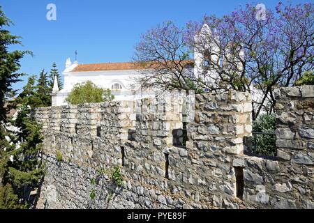 View of castle battlements with St Marys church (Igreja de Santa Maria do Castelo) to the rear, Tavira, Algarve, Portugal, Europe. Stock Photo