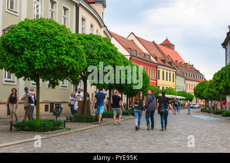 Tumski Island, young Polish people visiting Tumski Island walk along Katedralny, a Baroque street linking the Cathedral to Holy Cross Church, Wroclaw. Stock Photo