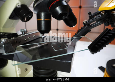 Microscope slide in robot arm and science microscope Stock Photo
