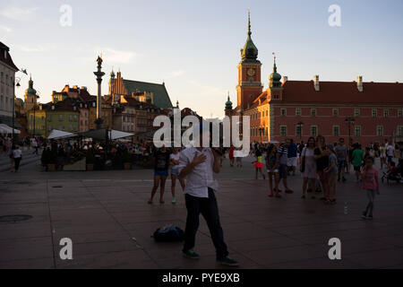 The castle square in Warsaw is a meeting place for tourists and locals who gather here to view street artists and concerts, Poland 2018. Stock Photo