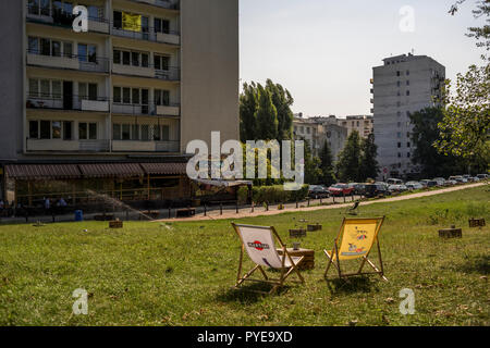 A lawn on Obozna street in Warsaw is furnished with beach chairs and tables for visitors to the café across the street, Poland 2018. Stock Photo