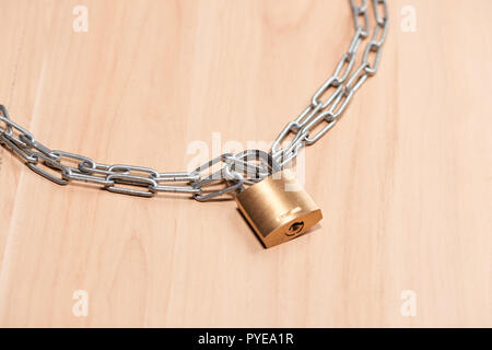 Key lock locked with a chain on table Stock Photo
