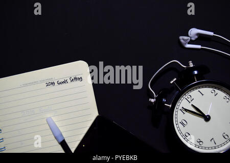 Notebook, smartphone, earphone and color pen with selective focus 2019 Goals setting text in black background, for business presentation or adding you Stock Photo