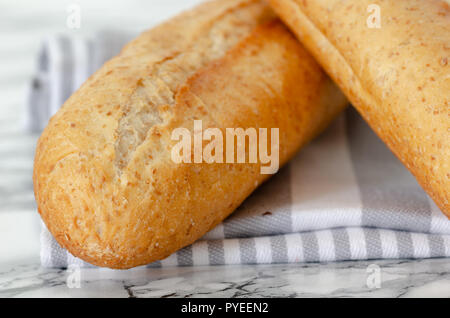 Freshly baked French baguettes on white wooden table. Top view, close up Stock Photo