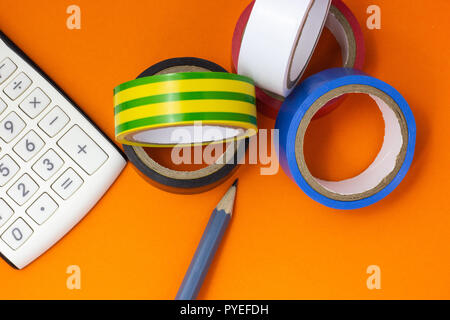 Calculator, insulating tape and pencil on an orange background Stock Photo