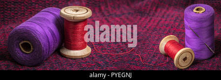 spools of colored threads, photo set against the background of knitted fabric Stock Photo