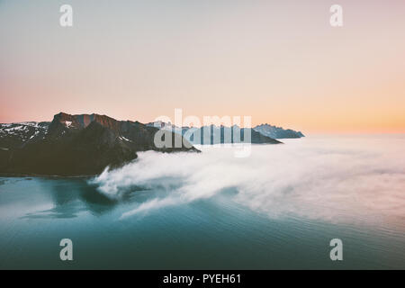 Sunset mountains and sea with clouds aerial landscape in Norway Travel vacations tranquil scenery Senja islands