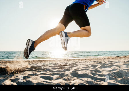 start running on sand athlete runner on beach in sunlight Stock Photo