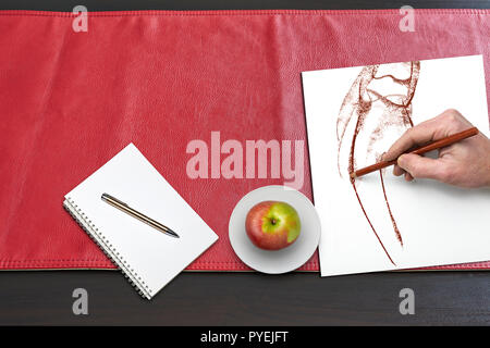 Apple and hand drawing on Red leather tablecloth, view from above Stock Photo