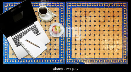 Notepad and notebook laptop on Two moroccan mosaic table, view from above Stock Photo