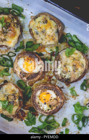 Mushrooms stuffed with quail eggs, on dark background Stock Photo