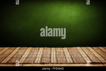 Empty bamboo table and green wall in background. Stock Photo