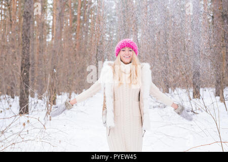 Winter, walks and people concept - young blond woman walking in the winter forest and throwing the snow up Stock Photo