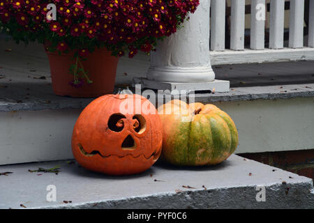 A jack-o-lantern on a front porch for Halloween. Stock Photo
