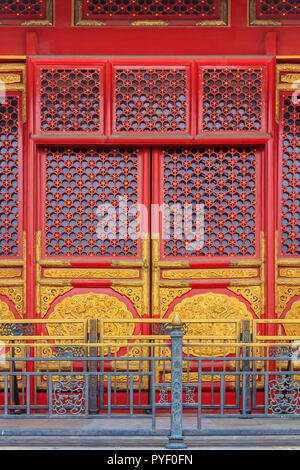 Ornate red wooden door with gold trim and traditional Chinese design at the Forbidden City, In Beijing, China Stock Photo