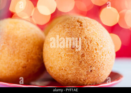 Traditional Colombian bunuelos (Deep Fried Cheese Bread) on christmas red background Stock Photo