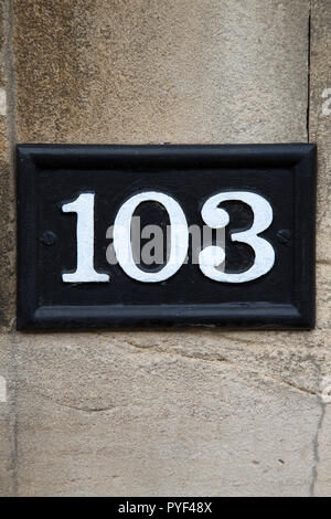 One Hundred and Three Number Sign on Stone Wall Stock Photo