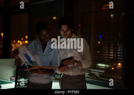 Executives discussing over digital tablet Stock Photo