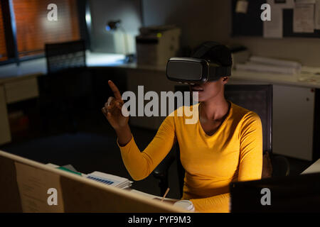 Female executive using virtual reality headset Stock Photo