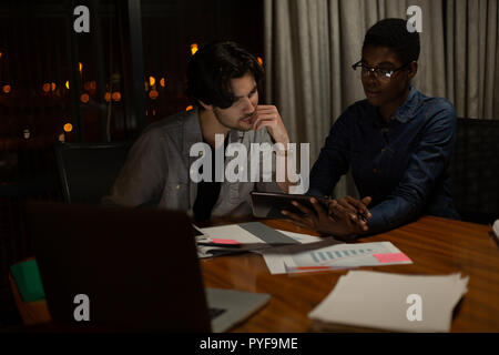 Executives discussing over digital tablet Stock Photo