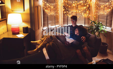 Couple using laptop in living room Stock Photo