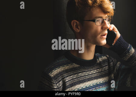 Man talking on mobile phone at home Stock Photo