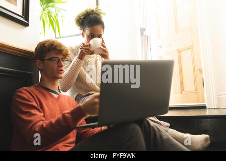 Couple having coffee while using laptop Stock Photo