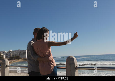 Couple taking selfie on promenade near beach Stock Photo