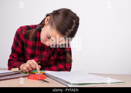 Concentrated girl using calculator on study table Stock Photo