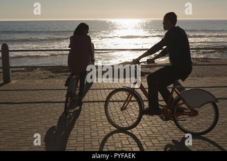 Couple riding bicycle on promenade Stock Photo